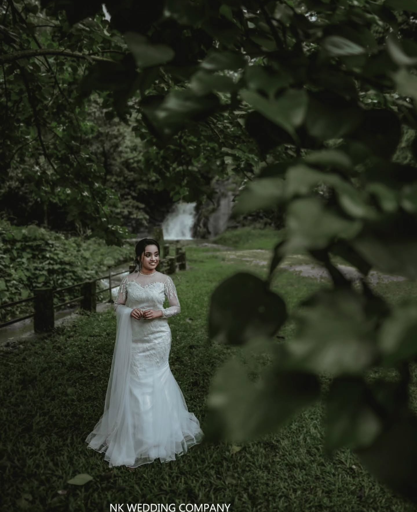 Bride framed by deep green foliage