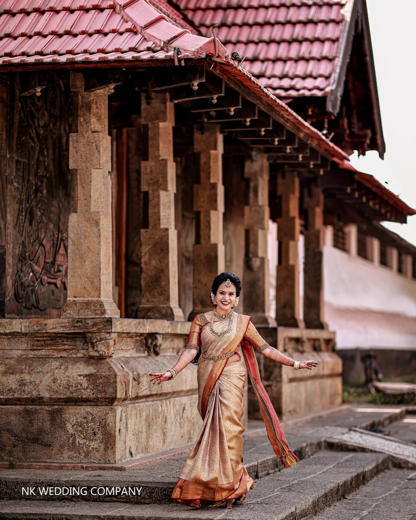 Bride in traditional attire crossing a heritage courtyard